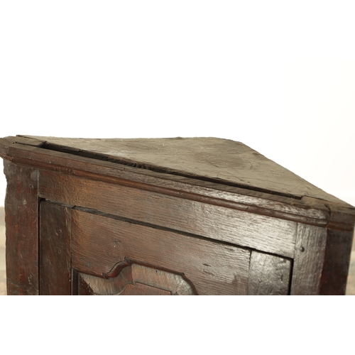 843 - AN EARLY 18TH CENTURY OAK HANGING CORNER CUPBOARD with hinged fielded panelled door and frieze drawe... 