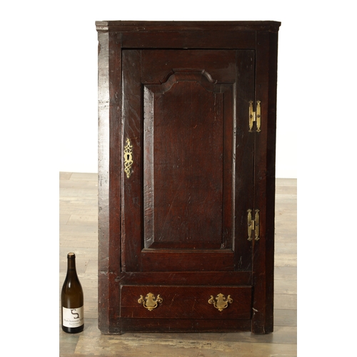 843 - AN EARLY 18TH CENTURY OAK HANGING CORNER CUPBOARD with hinged fielded panelled door and frieze drawe... 