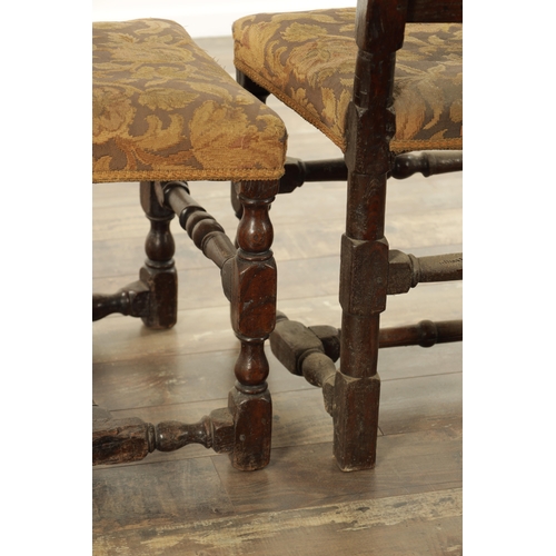 854 - A PAIR OF 17TH CENTURY OAK HALL CHAIRS with scroll-carved top rails above slatted backs, having upho... 