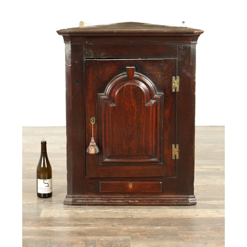 858 - A GOOD EARLY 18TH CENTURY WALNUT HANGING CORNER CUPBOARD with arched panelled door above a single dr... 