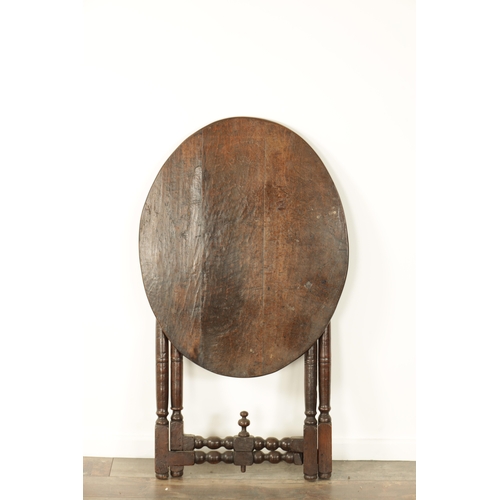 862 - AN EARLY 18TH CENTURY OAK FOLDING TAVERN TABLE with an oval top above a turned folding base (70cm wi... 