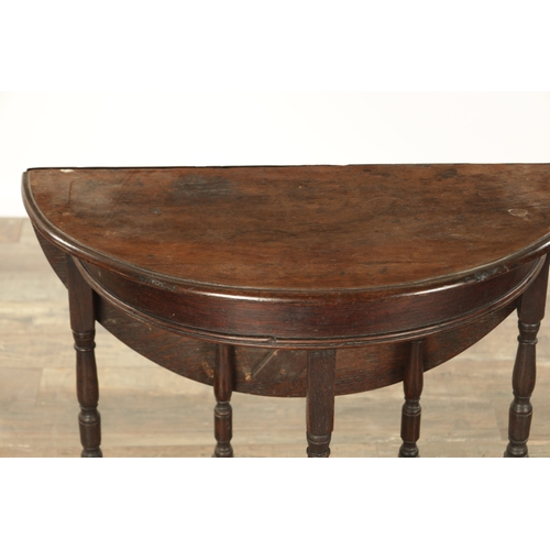 864 - AN EARLY 18TH CENTURY OAK DEMI LUNE SIDE TABLE with fold-down back and hinged top, raised on ring-tu... 