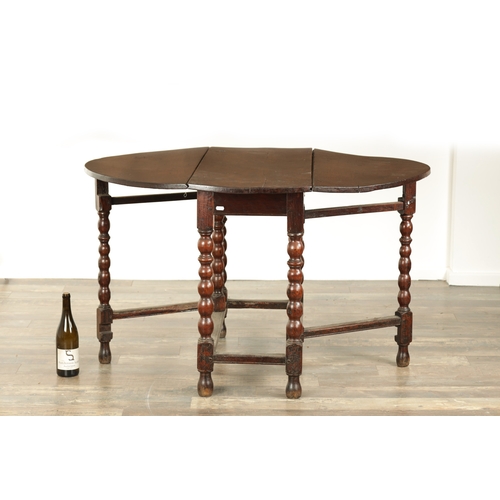 866 - AN EARLY 18TH CENTURY JOINED OAK GATE LEG TABLE the oval top on a bobbin-turned base with under stre... 