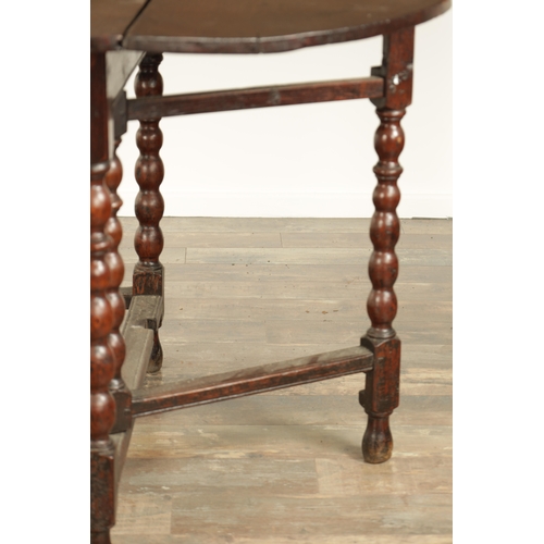 866 - AN EARLY 18TH CENTURY JOINED OAK GATE LEG TABLE the oval top on a bobbin-turned base with under stre... 