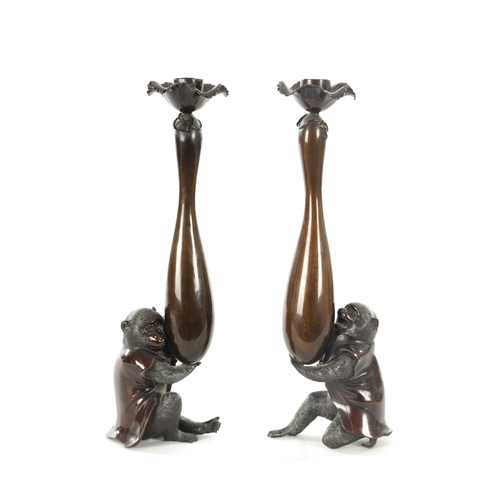 111 - A FINE PAIR OF JAPANESE MEIJI PATINATED BRONZE FIGURAL CANDLESTICKS the plain slender ovoid vase-sha... 