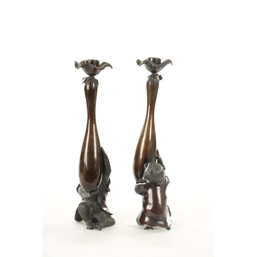 111 - A FINE PAIR OF JAPANESE MEIJI PATINATED BRONZE FIGURAL CANDLESTICKS the plain slender ovoid vase-sha... 