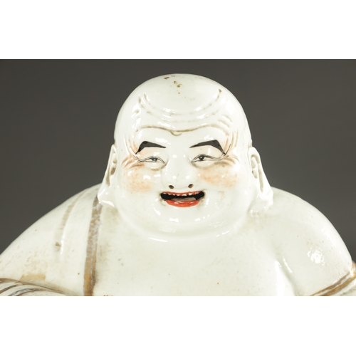 131 - A 19TH CENTURY CHINESE PORCELAIN STATUE OF A SEATED BUDDHA with iron red highlights - having impress... 