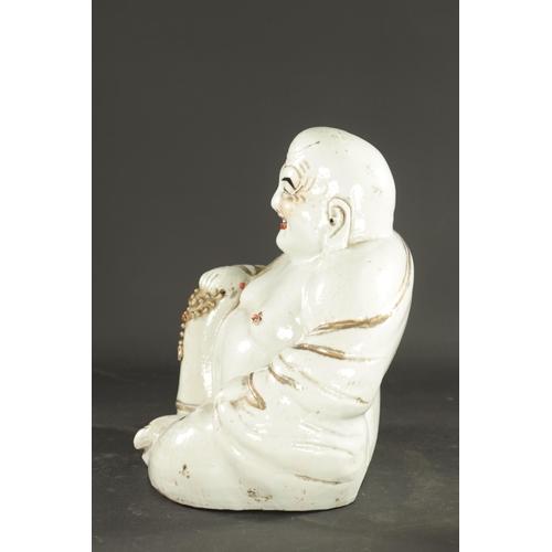 131 - A 19TH CENTURY CHINESE PORCELAIN STATUE OF A SEATED BUDDHA with iron red highlights - having impress... 