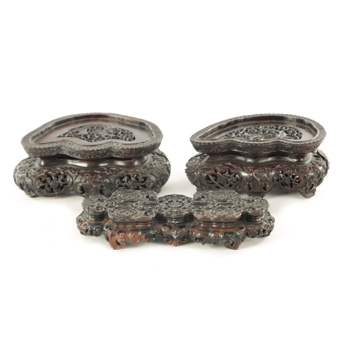 142 - A PAIR OF 19TH CENTURY CHINESE HARDWOOD STANDS AND ANOTHER of shaped pierced form with finely carved... 