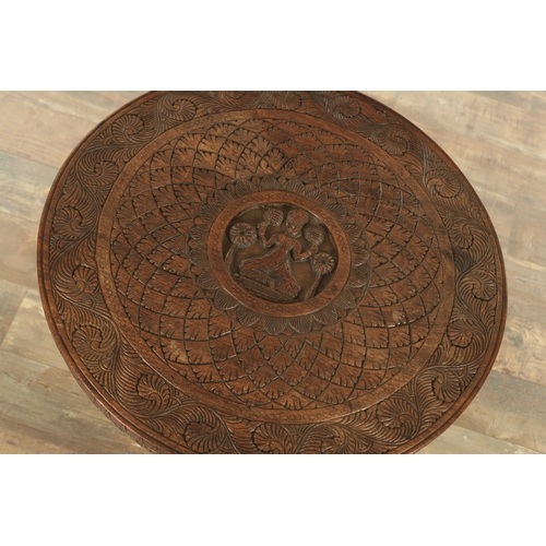 143 - A 19TH CENTURY INDIAN CARVED HARDWOOD OCCASIONAL TABLE the circular carved top above three elephant'... 