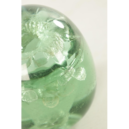 28 - A VICTORIAN GREEN GLASS DUMP PAPERWEIGHT with flower head centre. TOGETHER WITH AN EARLY 20TH CENTUR... 