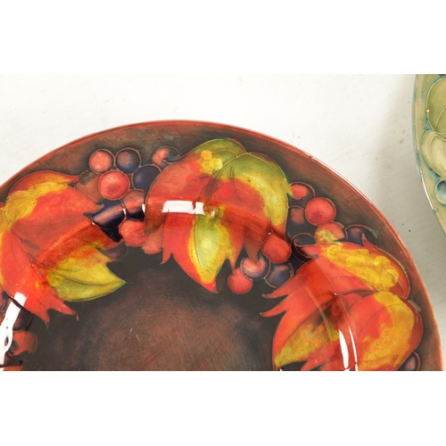 38 - A PAIR OF 1930/40'S W MOORCROFT PLATES decorated in the leaf and berry pattern under a flambe glaze ... 