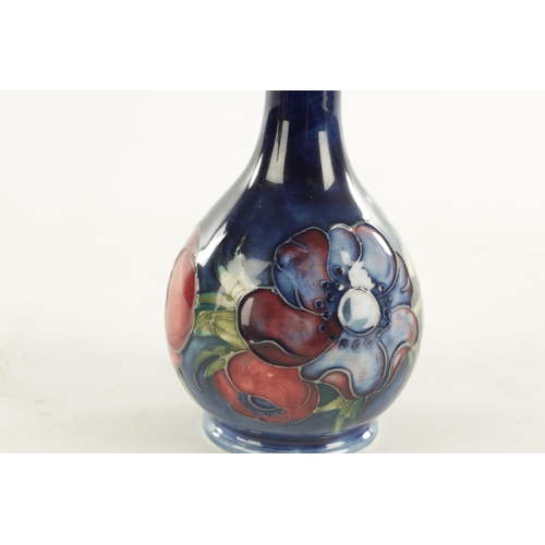 44 - A WALTER MOORCROFT ANEMONE PATTERN BULBOUS VASE with a slender neck and label to under side. (15cm h... 