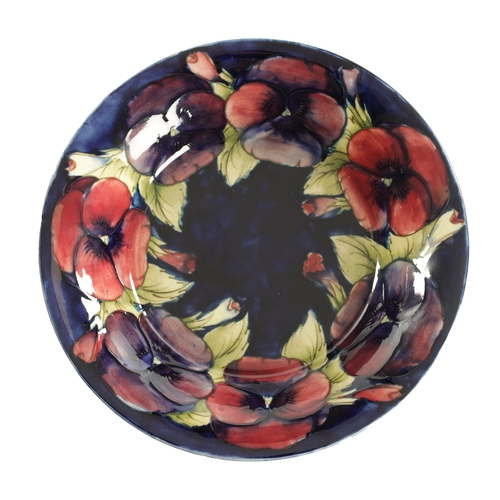 69 - A 1930'S MOORCROFT LARGE SHALLOW FRUIT DISH with inverted rim decorated in the big pansy pattern on ... 