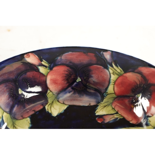 69 - A 1930'S MOORCROFT LARGE SHALLOW FRUIT DISH with inverted rim decorated in the big pansy pattern on ... 