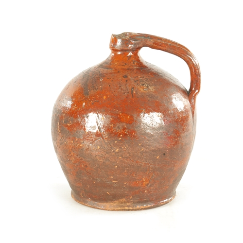 76 - AN EARLY BROWN GLAZED TERRACOTTA WINE JAR of shouldered form with ribbed handle. (21cm high)