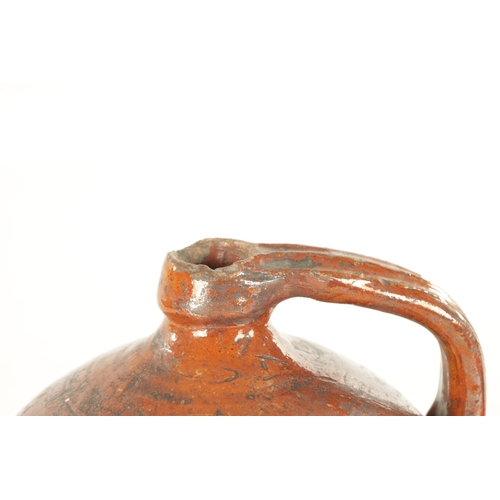 76 - AN EARLY BROWN GLAZED TERRACOTTA WINE JAR of shouldered form with ribbed handle. (21cm high)