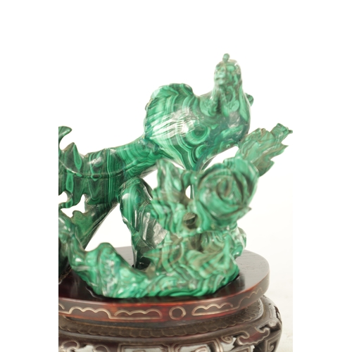 91 - A LATE 19TH CENTURY CHINESE CARVED MALACHITE SCULPTURE of a bird in foliate setting; raised on a wir... 