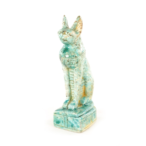 209 - AN EARLY EGYPTIANESQUE STONEWARE SCULPTURE OF A CAT seated in an alert pose on a plinth base glazed ... 