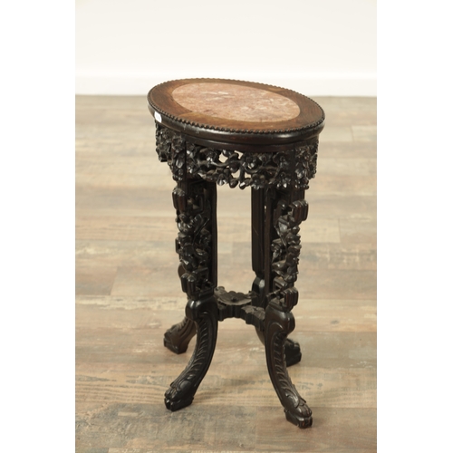 220 - A 19TH CENTURY CHINESE HARDWOOD OVAL SHAPED VASE STAND with inset marble top and cutout frieze and c... 