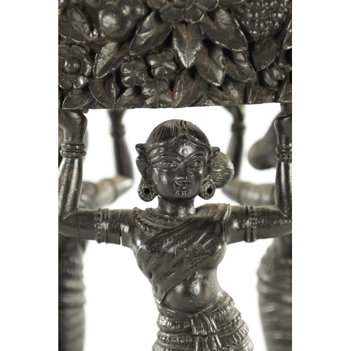 225 - A 19TH CENTURY CARVED EBONY ANGLO INDIAN JARDINIERE STAND with figural supports and leaf carved deco... 