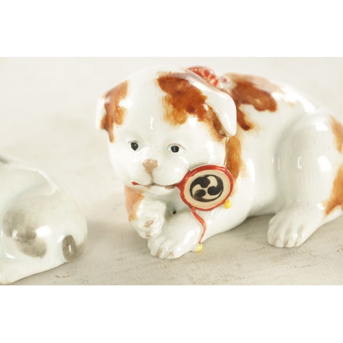 227 - TWO JAPANESE MEIJI PERIOD PORCELAIN FIGURES OF RECUMBENT DOGS one with incised marks for Makuzu Koza... 