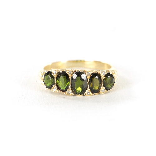 235 - AN 18CT GOLD TOURMALINE AND DIAMOND RING, the five oval cut peridots on a pierced scrollwork mount w... 