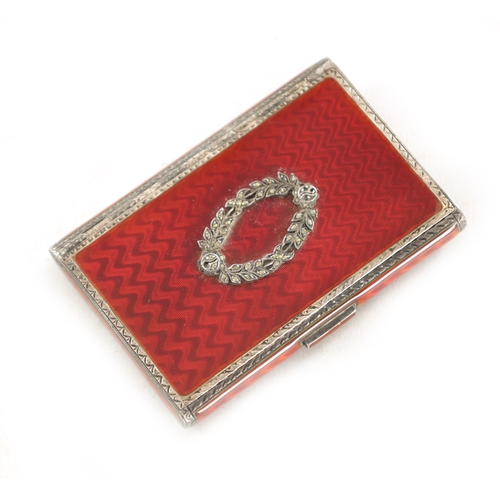 258 - AN ART DECO SILVER AND RED GUILLOCHE ENAMEL CIGARETTE CASE, with engraved border and mounted garland... 