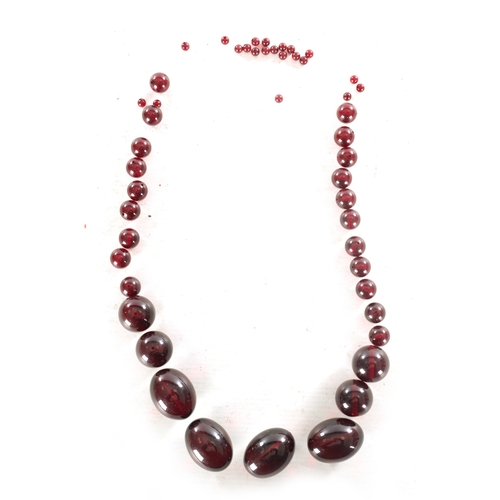 273 - A COLLECTION OF 19TH CENTURY RED AMBER BEADS of varying ovoid and spherical shape.