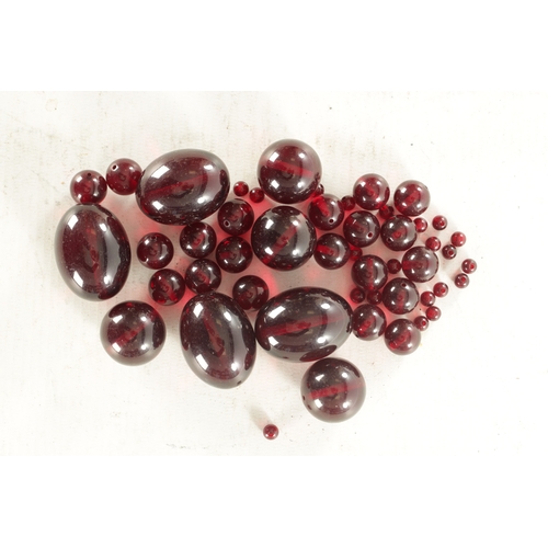 273 - A COLLECTION OF 19TH CENTURY RED AMBER BEADS of varying ovoid and spherical shape.