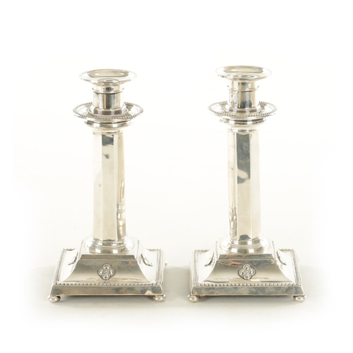 367 - A STYLISH PAIR OF GEORGE V LIBERTY & CO SILVER CANDLESTICKS the bead-edged raised double sconces on ... 