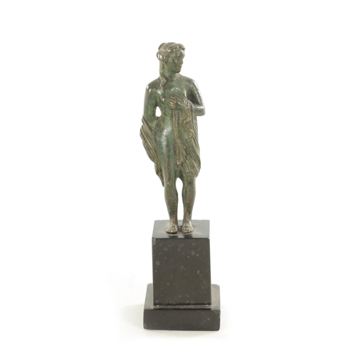 673 - AN EARLY BRONZE FIGURAL SCULPTURE modelled as a semi nude maiden on later black marble base. (17cm h... 