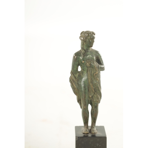 673 - AN EARLY BRONZE FIGURAL SCULPTURE modelled as a semi nude maiden on later black marble base. (17cm h... 