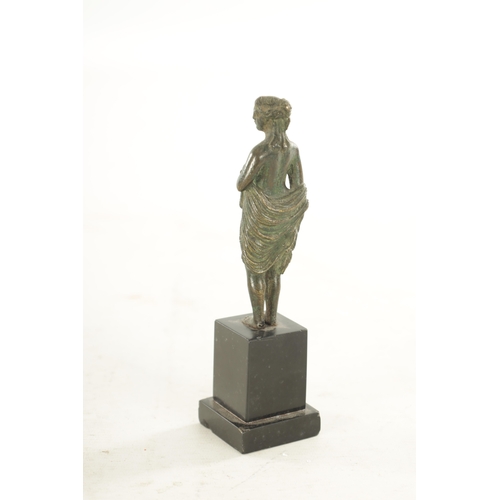 673 - AN EARLY BRONZE FIGURAL SCULPTURE modelled as a semi nude maiden on later black marble base. (17cm h... 