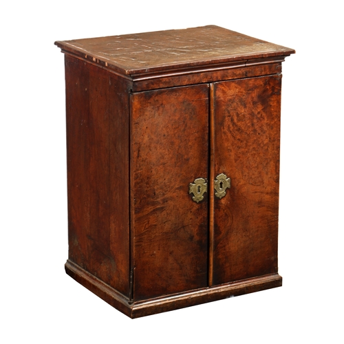 1392 - A WILLIAM AND MARY BURR WALNUT HANGING CUPBOARD the moulded cornice above a pair of hinged doors enc... 