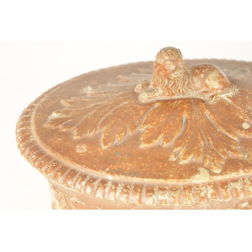 105 - A 19TH CENTURY CONTINENTAL EARTHENWARE TUREEN with leaf moulded and swag work decoration with recumb... 