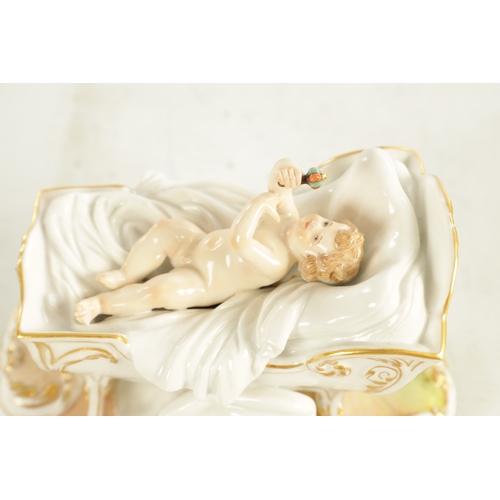 106 - A 19TH CENTURY MEISSEN CRADLE AND CHERUB FIGURE of elaborate design highlighted in gilt and set on a... 