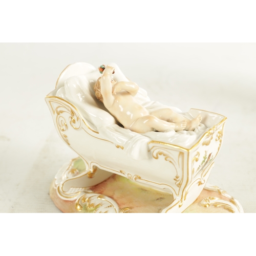 106 - A 19TH CENTURY MEISSEN CRADLE AND CHERUB FIGURE of elaborate design highlighted in gilt and set on a... 