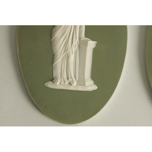 117 - A PAIR OF LATE 19TH CENTURY WEDGWOOD PALE GREEN OVAL JASPER WARE PANELS with raised decoration of cl... 