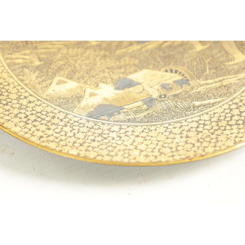 139 - A JAPANESE MEIJI PERIOD GILT BRONZE KOMAI PLATE finely decorated with houses and a mill below Mount ... 