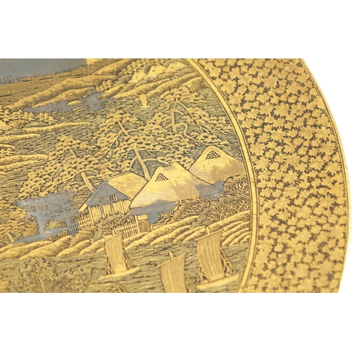 139 - A JAPANESE MEIJI PERIOD GILT BRONZE KOMAI PLATE finely decorated with houses and a mill below Mount ... 