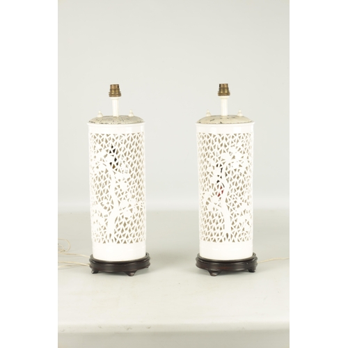 143 - A PAIR OF 20TH CENTURY CHINESE BLANC DE CHINE TABLE LAMPS decorated with pierced bamboo bodies on ha... 