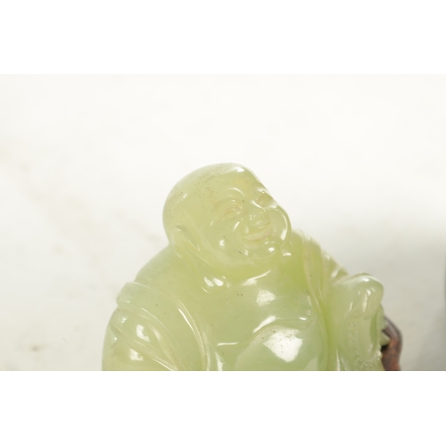 146 - A CHINESE CARVED JADE SCULPTURE OF A SEATED BUDDHA on a hardwood base (13cm wide 8cm high )