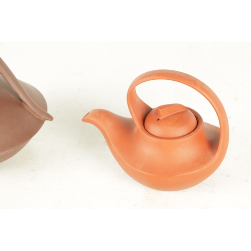 154 - TWO CHINESE TERRACOTTA TEAPOTS with slim saucer-shaped bodies and shaped handles and lift-off fin ha... 