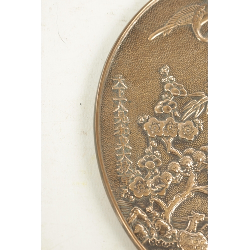 179 - A JAPANESE SILVERED BRONZE HAND MIRROR with relief cast front decorated with blooming trees and stor... 