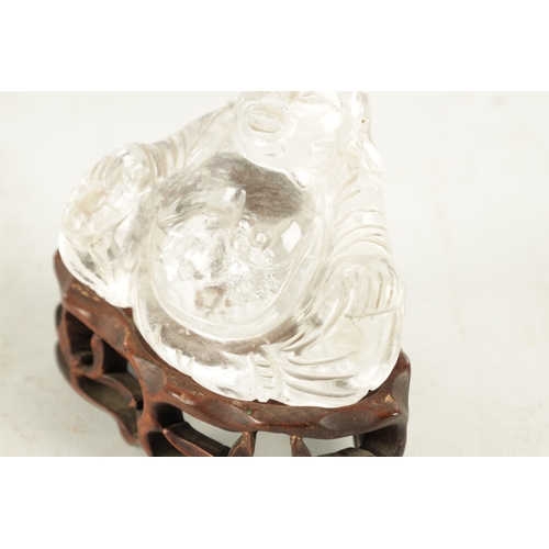 203 - AN EARLY 20TH CENTURY CHINESE CARVED ROCK CRYSTAL SCULPTURE modelled as a seated Buddha on hardwood ... 