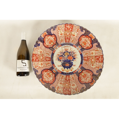 207 - A 19TH CENTURY IMARI CHARGER with a fluted border decorated with brightly coloured floral designs hi... 