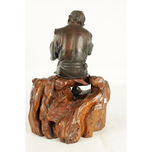 215 - A LARGE JAPANESE MEIJI PERIOD OKIMONO ON ROOT WOOD BASE depicting a robed elder seated with a teapot... 