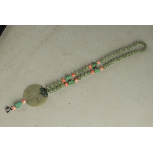 234 - A JADE AND CORAL NECKLACE with a circular engraved jade pendant depicting a fish with brightly colou... 