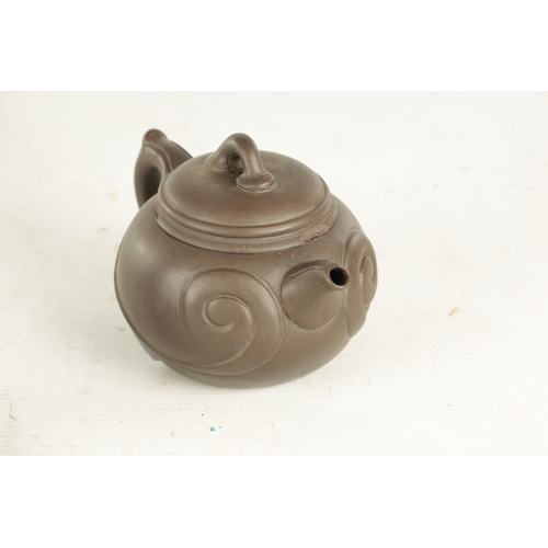 239 - TWO CHINESE TERRACOTTA TEAPOTS with scrolled embossed bodies and impressed mark to underside (9cm hi... 